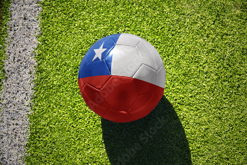 football ball with the flag of chile on the green field near the white line