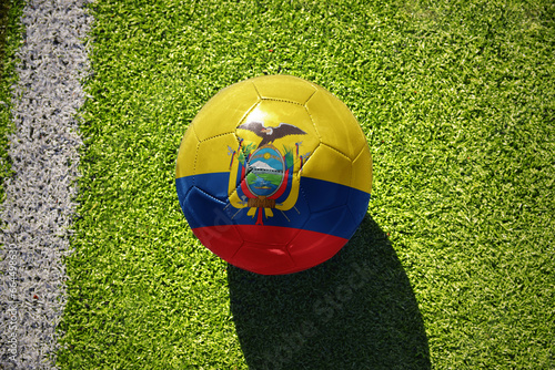 football ball with the flag of ecuador on the green field near the white line