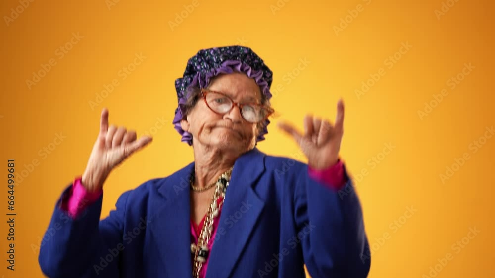 Portrait of shaka hand gesture given by funny crazy grandmother mature woman, 80s, isolated on yellow background. Concept of elderly rock and roll. Portrait of shaka hand gesture given by funny crazy grandmother mature woman, 80s, isolated on yellow background. Concept of elderly rock and roll.