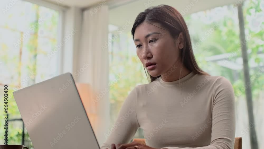 Medium shot of young female solopreneur analyzing data on laptop while working from home Medium shot of young female solopreneur analyzing data on laptop while working from home