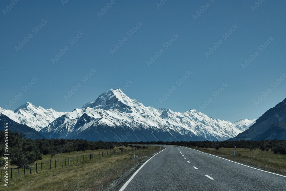 Mount Cook in New Zealand, framed by a road and a flawless blue sky, embodies freedom at its best.