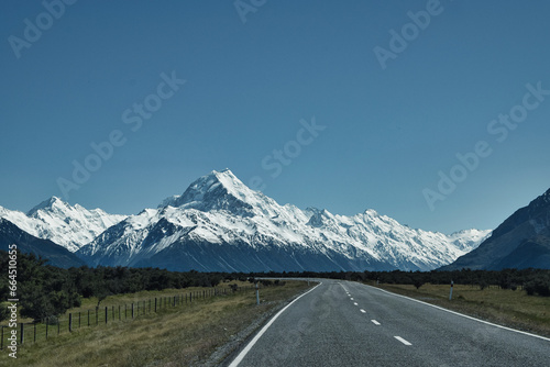 Mount Cook in New Zealand, framed by a road and a flawless blue sky, embodies freedom at its best.