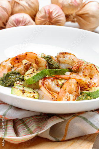 Fitness dish with grilled shrimp and zucchini on wooden white vintage background