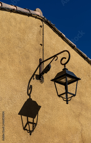 An old lantern and its shadow on a facade