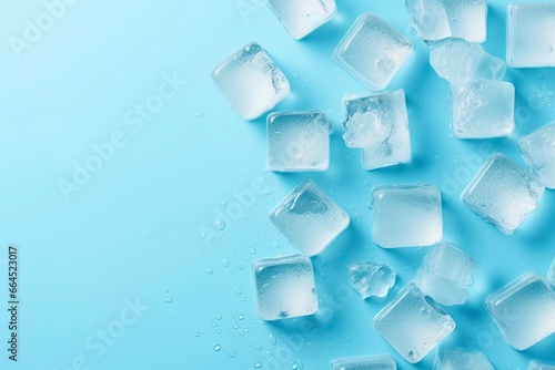Cubes of ice and drops are isolated on the blue background with empty space.