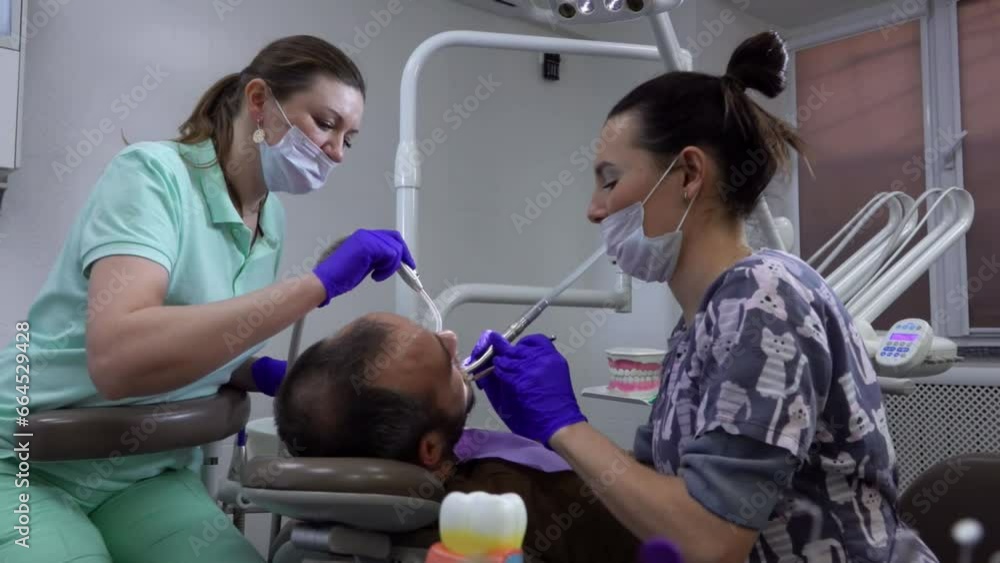 Female dentist and nurse are making tooth treatment in dental clinic Female dentist and nurse are making tooth treatment in dental clinic