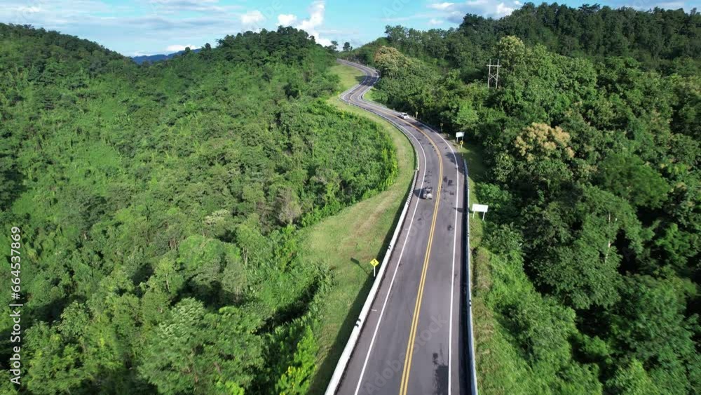 Aerial view highway Drone flying above winding road during sunlight, Winding asphalt road through tropical rainforest. countryside landscape. Landmark tourist attractions in Nan Province, Thailand. Aerial view highway Drone flying above winding road during sunlight, Winding asphalt road through tropical rainforest. countryside landscape. Landmark tourist attractions in Nan Province, Thailand.
