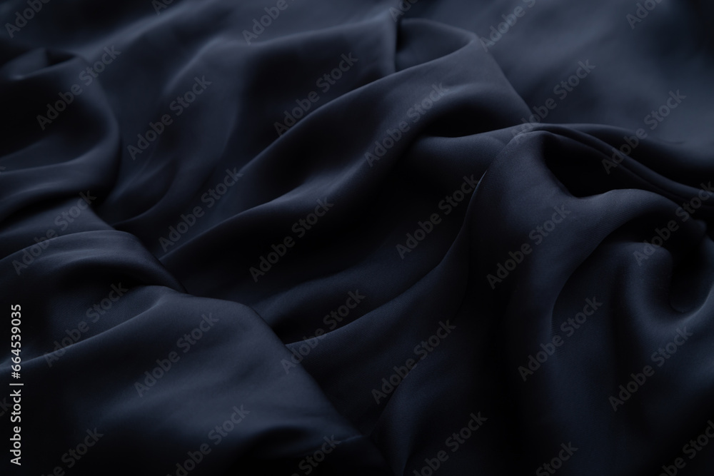 Black crumpled fabric folds background.  Black history month concept. Soft focus texture of the silk fabric, soft black.