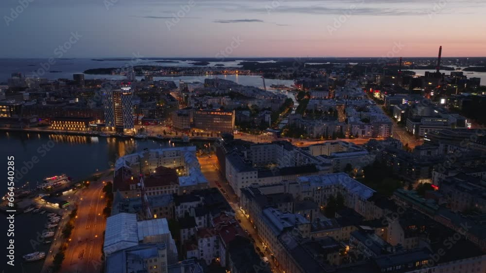 Aerial view of town development in urban borough at dusk. Modern structures at waterfront. Helsinki, Finland Aerial view of town development in urban borough at dusk. Modern structures at waterfront. Helsinki, Finland