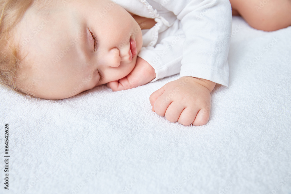 Cute baby sweetly sleeps on white bed linen in white clothes. Close-up. Beautiful healthy soft skin, long eyelashes. Cute baby sweetly sleeps on white bed linen in white clothes. Close-up. Beautiful healthy soft skin, long eyelashes.