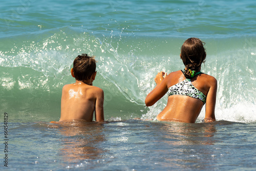 Children in the sea before the wave