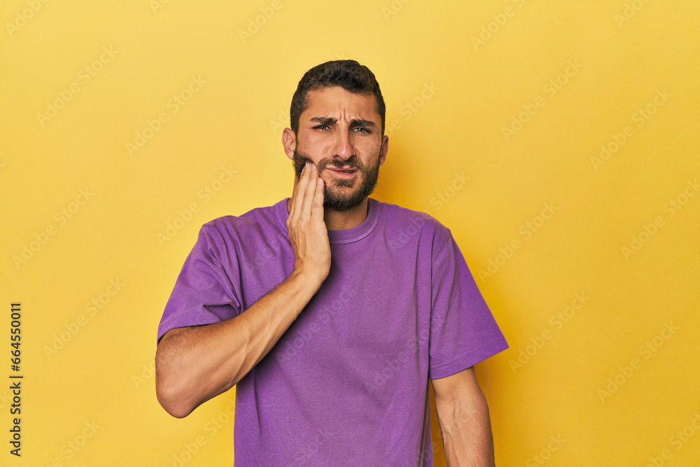 Young Hispanic man on yellow background having a strong teeth pain, molar ache. Young Hispanic man on yellow background having a strong teeth pain, molar ache.