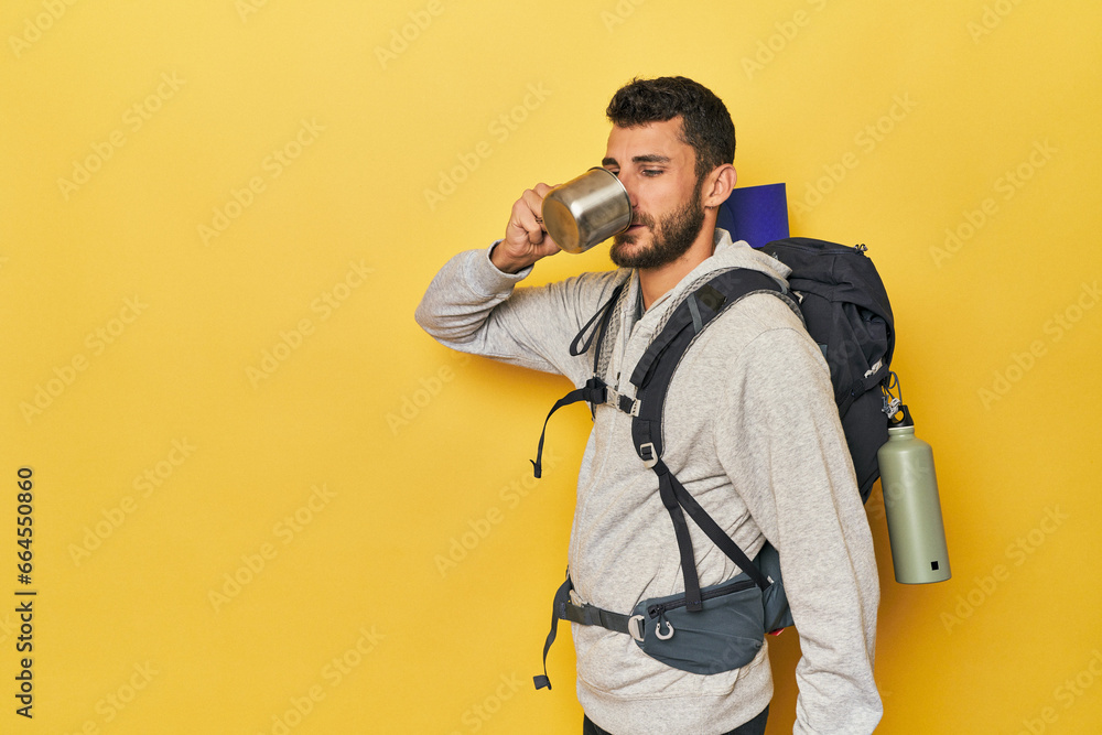Young Hispanic man with camping mug and pack Young Hispanic man with camping mug and pack