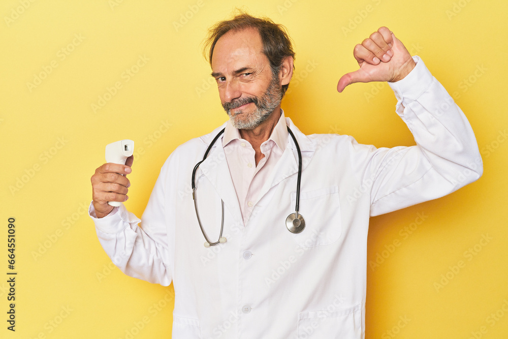 Doctor holding infrared thermometer in studio feels proud and self confident, example to follow. Doctor holding infrared thermometer in studio feels proud and self confident, example to follow.