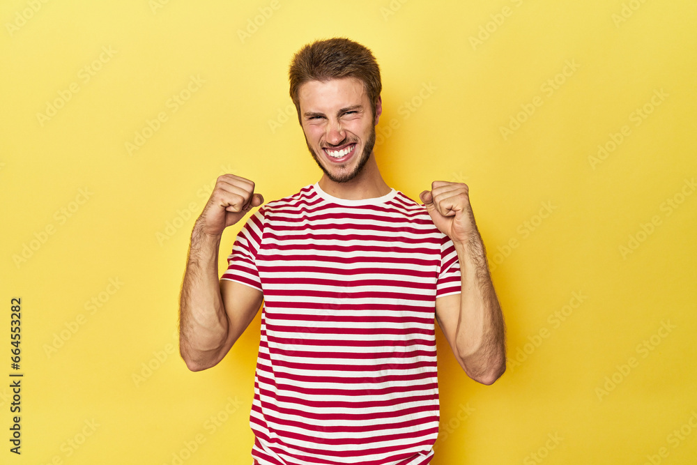 Young Caucasian man on a yellow studio background cheering carefree and excited. Victory concept. Young Caucasian man on a yellow studio background cheering carefree and excited. Victory concept.
