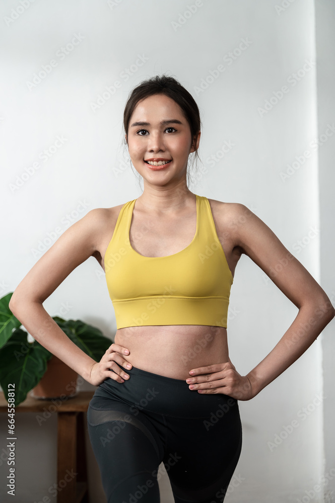 Young beautiful Asian woman stretching before practice yoga at home alone prevent covid infection follow social distancing order. New normal lifestyle exercise and health care concept. Young beautiful Asian woman stretching before practice yoga at home alone prevent covid infection follow social distancing order. New normal lifestyle exercise and health care concept.