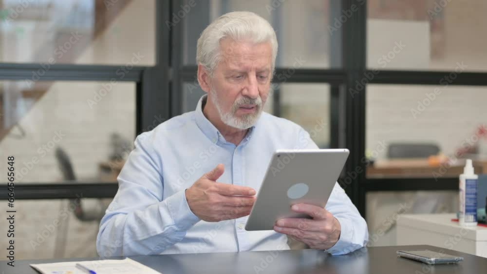 Old Businessman Doing Video Chat on Tablet in Office Old Businessman Doing Video Chat on Tablet in Office
