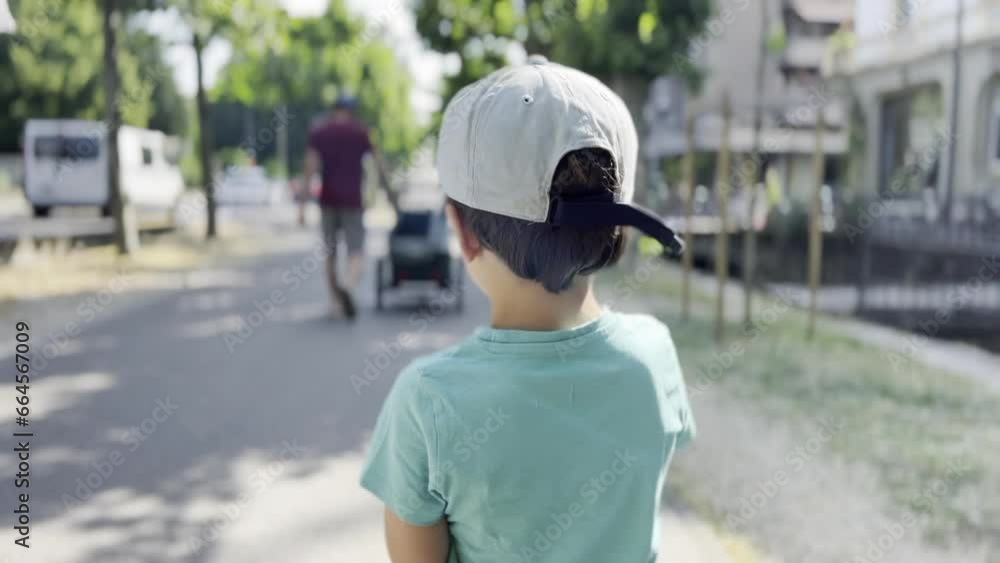 Daytime Sidewalk Walk - Boy Slows Pace Down, Behind Mom, Quietly Expressing Fatigue and Discontent, Childhood Tricks Daytime Sidewalk Walk - Boy Slows Pace Down, Behind Mom, Quietly Expressing Fatigue and Discontent, Childhood Tricks
