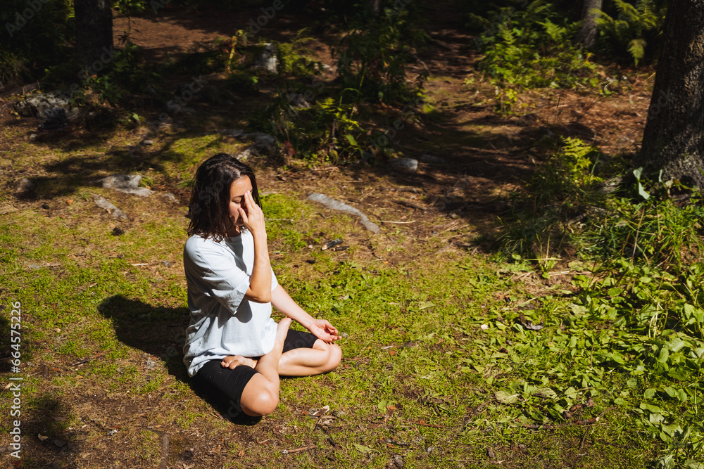 Om chanting, mind calming practice, girl doing yoga, hatha yoga in nature, lotus pose sitting on the grass, unity with nature. Om chanting, mind calming practice, girl doing yoga, hatha yoga in nature, lotus pose sitting on the grass, unity with nature.