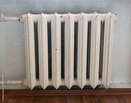 Wallpaper Mural a rusted leaking pipe and an old cast-iron heating radiator with peeling white paint on the wall in close-up Torontodigital.ca