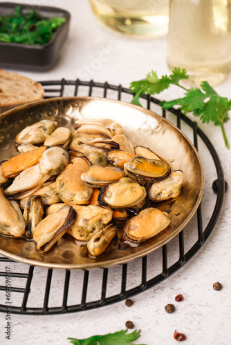 Plate of pickled mussels on grey background