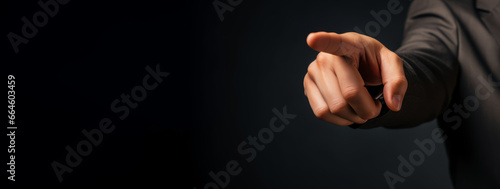 Ein Geschäftsmann im Anzug, zeigt mit dem Zeigefinger in richtung Kamera. 