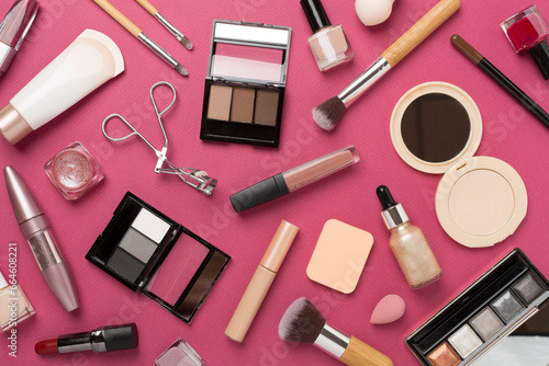 Flat lay with makeup products and tools on color background