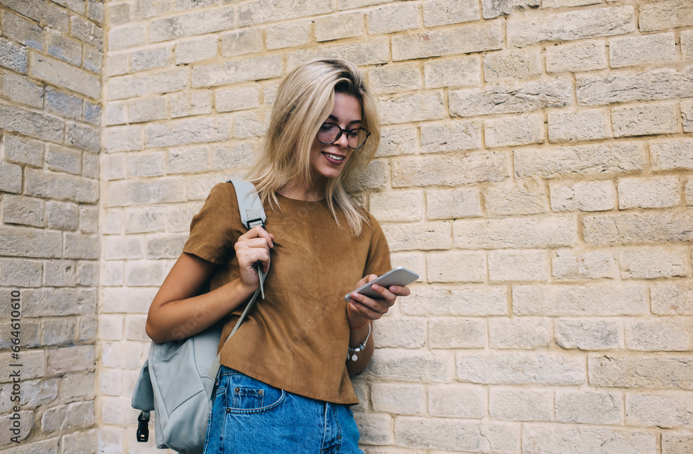 Φωτογραφία Cheerful hipster girl in classic eyeglasses chatting with followers from social