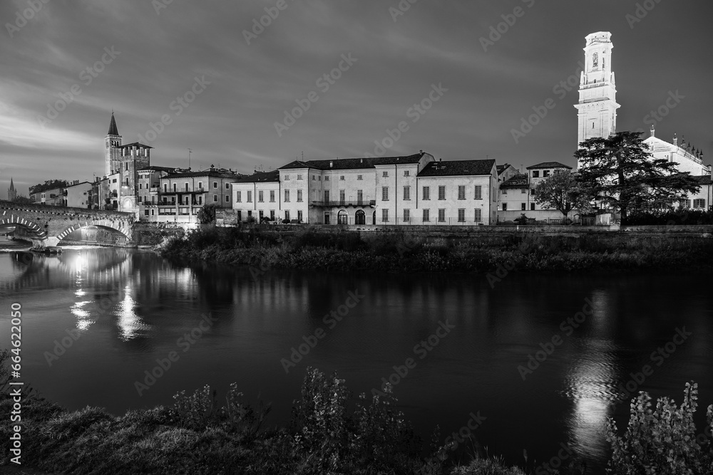 Verona, Veneto, Italy: Twilight view of Agige river waterfront with the Cathedral of St. Mary and the Stone Bridge and tower in black and white