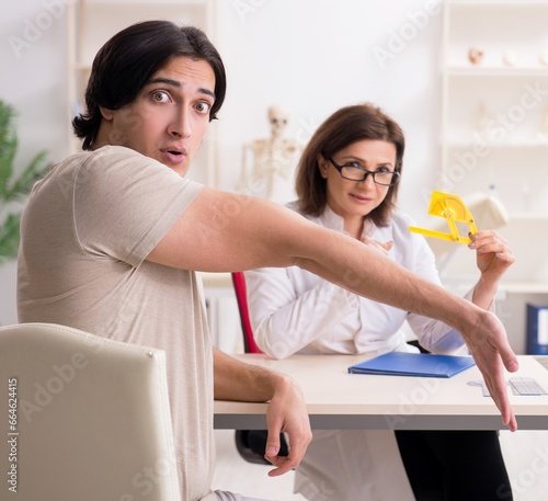 Female doctor checking patient's joint flexibility with goniomet photo