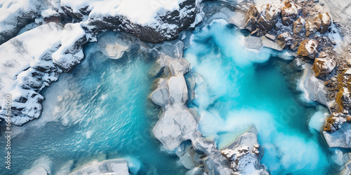 Aerial view of a thermal spring, surrounded by snowy mountains, turquoise blue hot water, high contrast