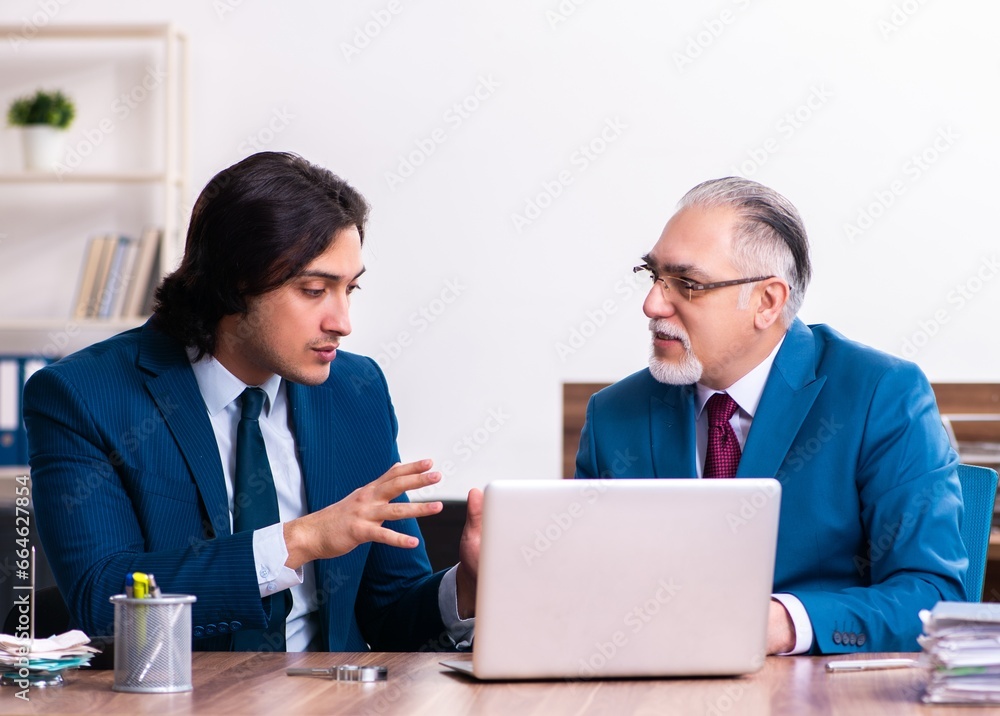 Young and old employees working together in the office Young and old employees working together in the office