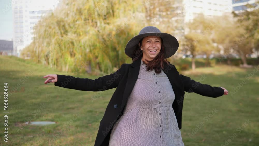 Happy pregnant woman spinning in the park and smiling 4k slow motion Happy pregnant woman spinning in the park and smiling 4k slow motion