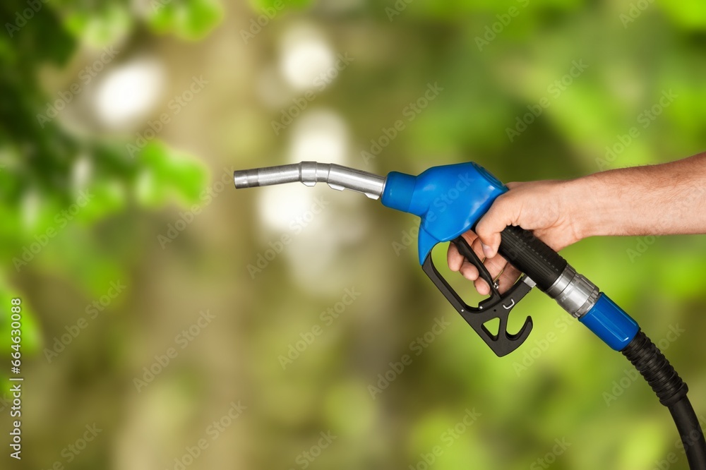 Naklejka premium Hand with classic fuel nozzle, decarbonization concept