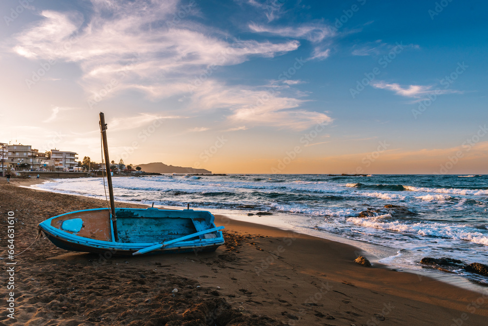 traditional Greek fishing boat on the shore at sunset on Crete, Greece. traditional Greek fishing boat on the shore at sunset on Crete, Greece.