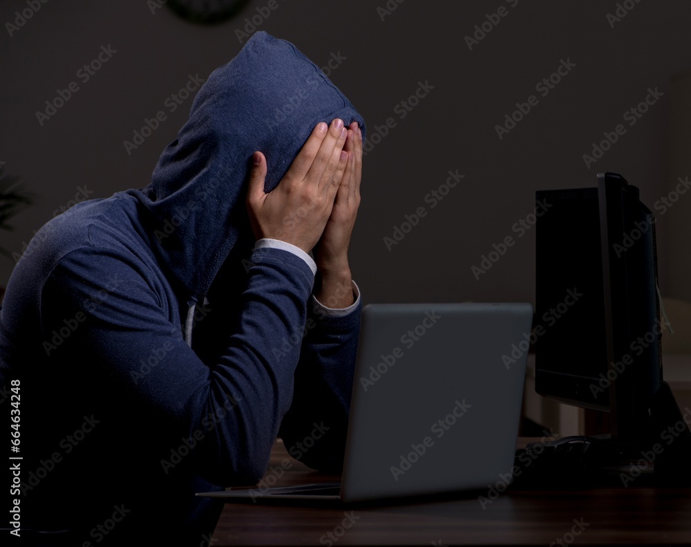 Male hacker hacking security firewall late in office Male hacker hacking security firewall late in office