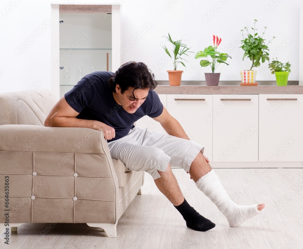 Leg injured young man suffering at home Leg injured young man suffering at home