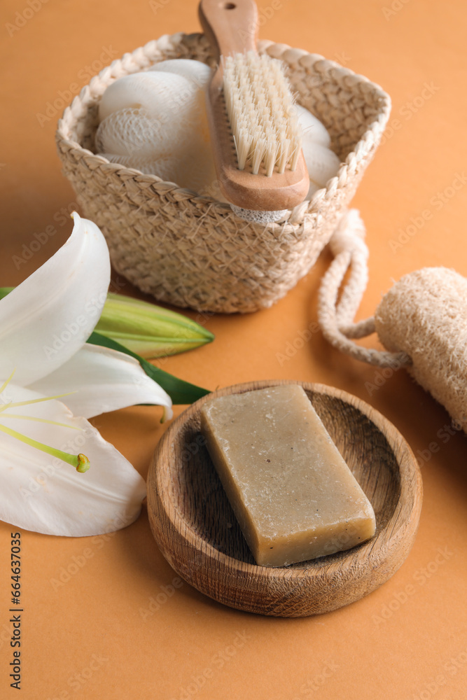 Bowl with soap bar, bath accessories and lily flowers on color background Bowl with soap bar, bath accessories and lily flowers on color background