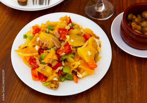 cuisine spanish salad with cod and potato in white plate for brunch