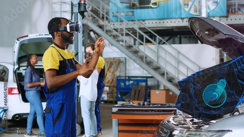 Serviceman in car service using advanced virtual reality technology to visualize motor turbine in order to fix it. Garage professional wearing VR glasses while servicing malfunctioning vehicle