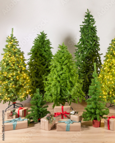 Vibrant array of Green Artificial Christmas trees, both lit with golden fairy lights and undecorated, surrounded by elegantly wrapped presents on a wooden floor, festive spirit of the holiday season.