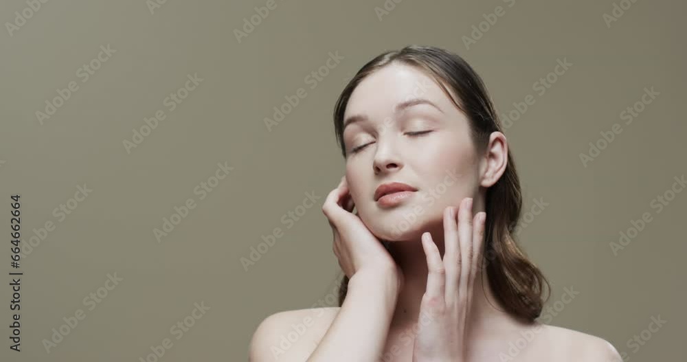 Caucasian woman with brown hair touching face, copy space, slow motion Caucasian woman with brown hair touching face, copy space, slow motion