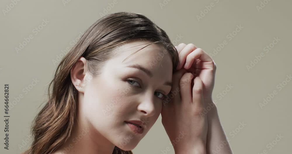 Caucasian woman with brown hair touching face, copy space, slow motion Caucasian woman with brown hair touching face, copy space, slow motion