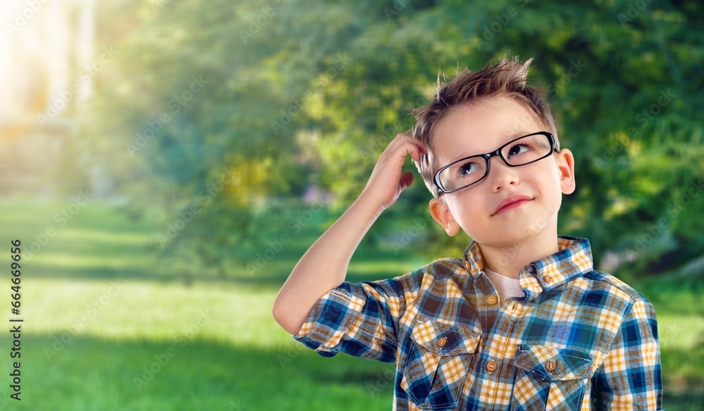 Thinking small student kid in a park. Thinking small student kid in a park.