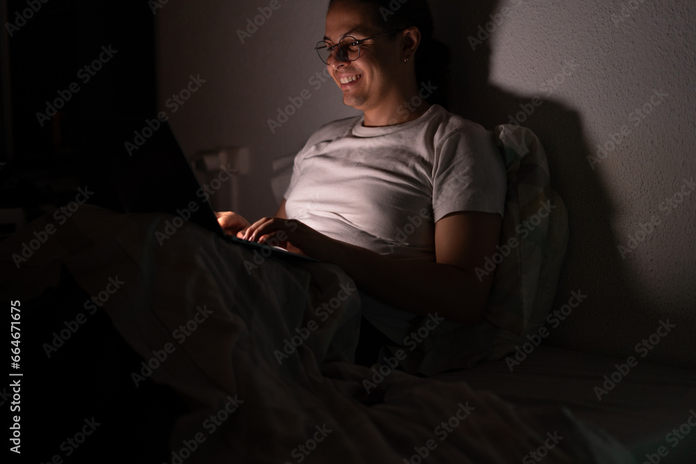 young man watching a series in bed at night after a long day at work