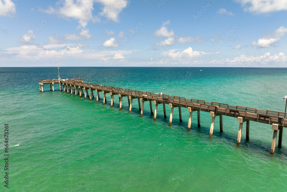 Idyllic summer day over Venice fishing pier in Florida. Summer seascape with surf waves crashing on sea shore