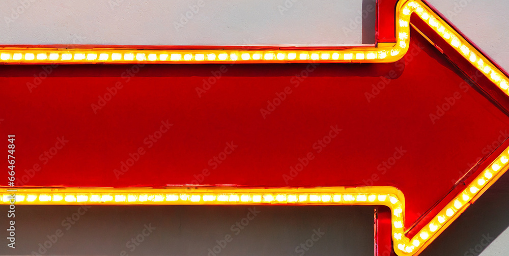 blank red arrow sign board with retro yellow neon light bulbs isolated on white wall backgro