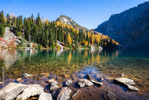 Picturesque view on Blue Lake. Autumn mountains landscape with Blue Lake and bright orange larches in the North Cascades National Park in Washington State, USA.
