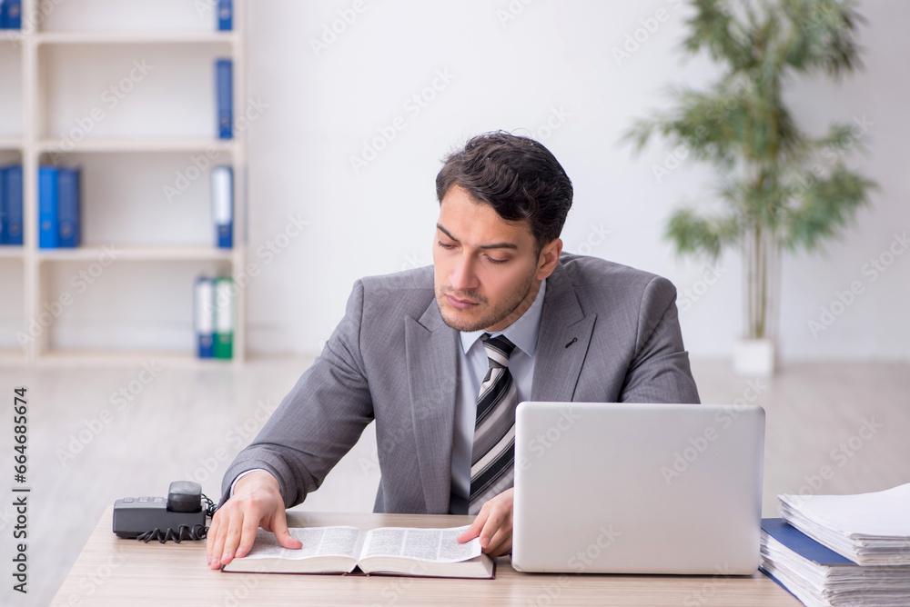 Fototapeta premium Young male employee working in the office