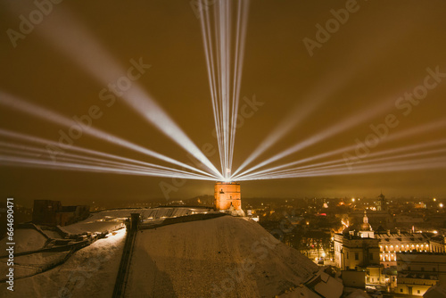 Scenic aerial view of Gediminas tower in Vilnius Old Town beautifully illuminated for 700th birthday celebration. Main symbol of Lithuanian capital at night.